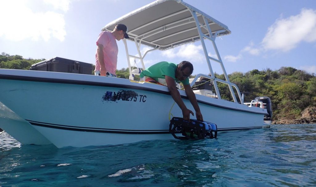 A <em>BlueROV2</em> being deployed with a hydrophone sensor to record sounds on the reef. (Credit: Yogesh Girdhar, WHOI)